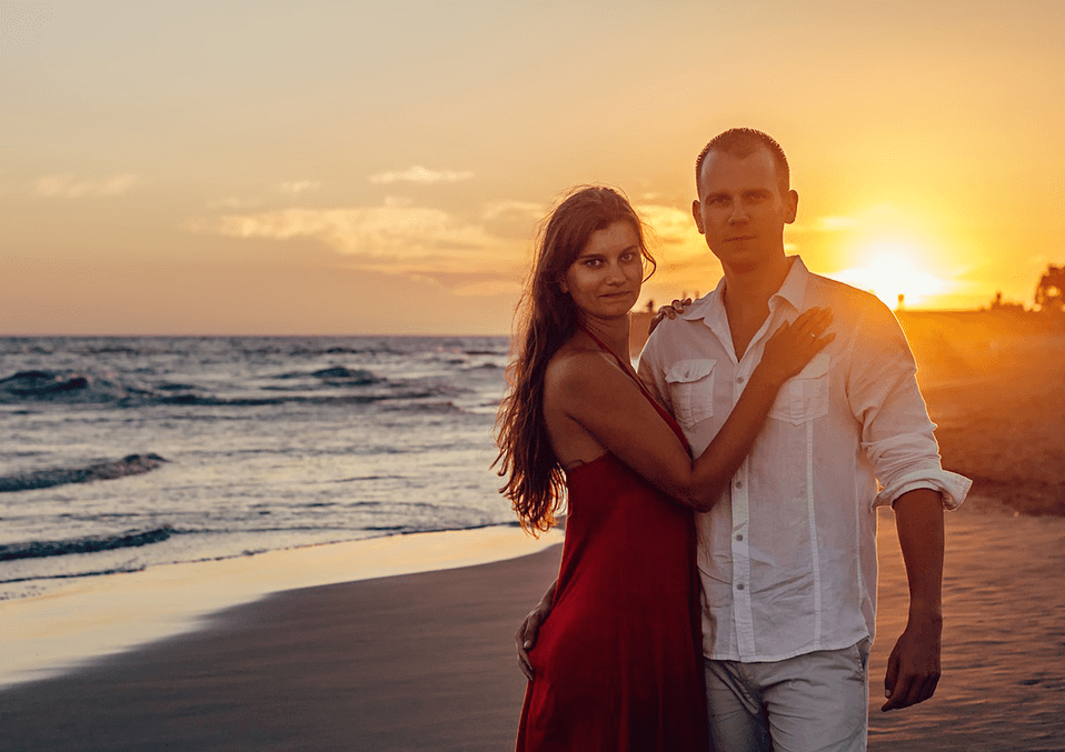 a couple next to a sunset