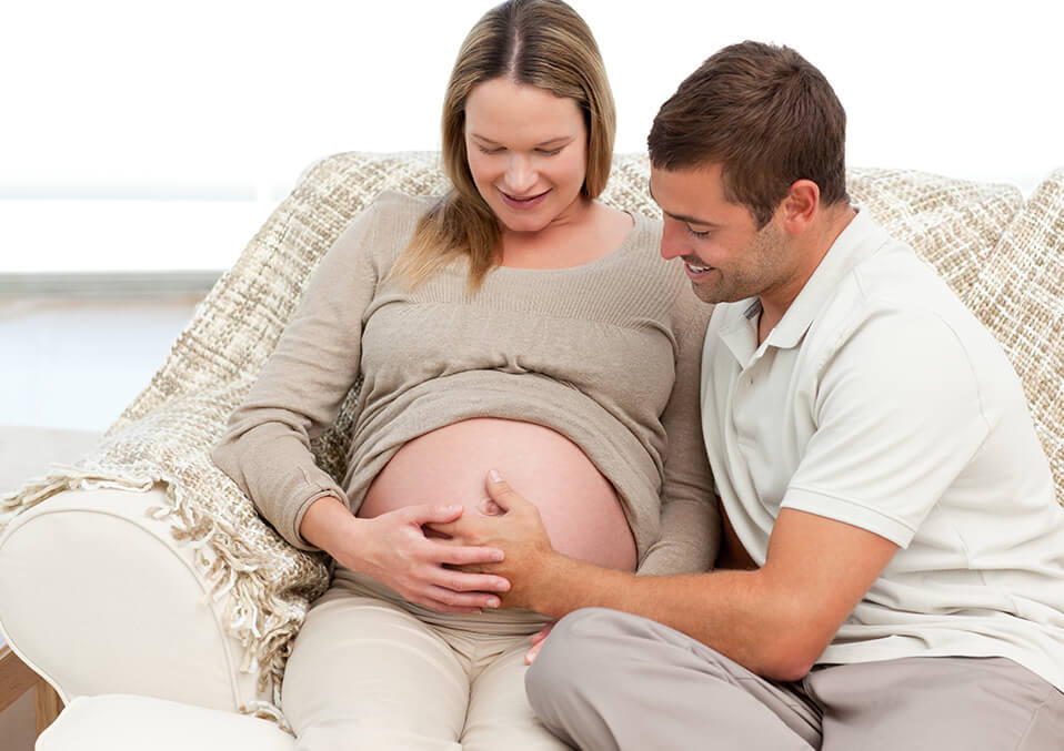 a man touching a pregnant womans belly