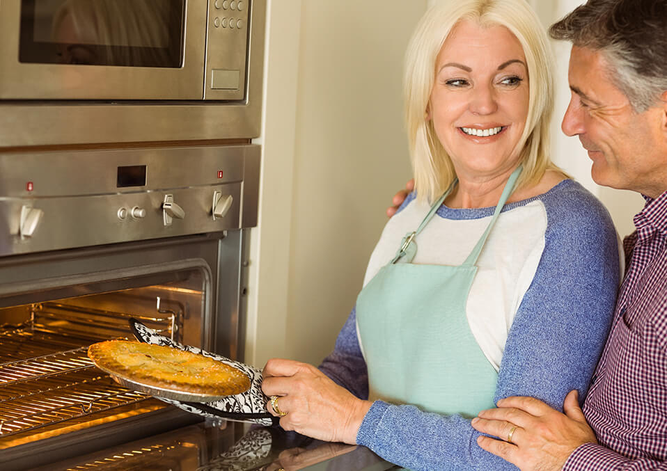 a woman taking a cake from the oven