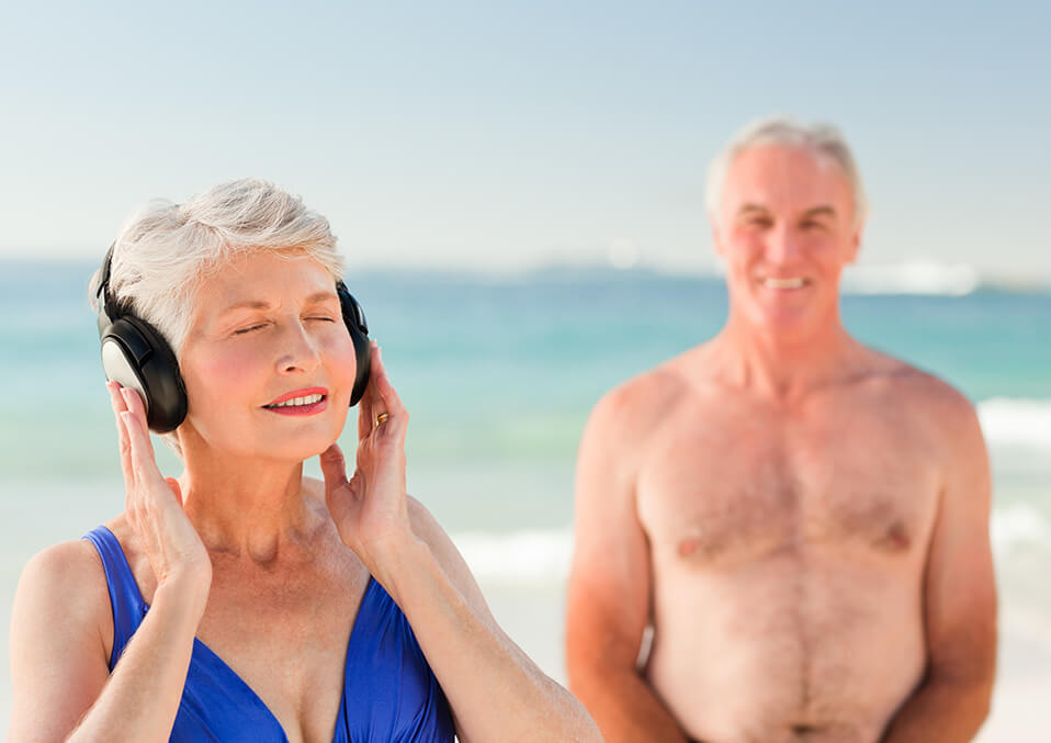 an old man and woman listening to music