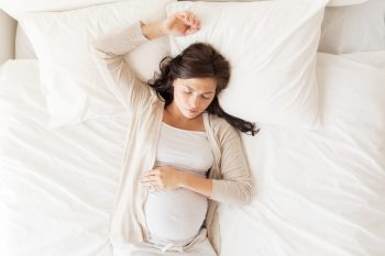 How should I lay in bed to induce labor?